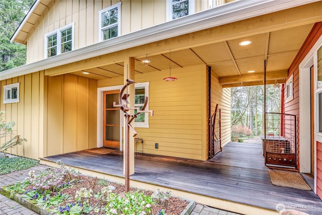 view of exterior entry with a porch and board and batten siding