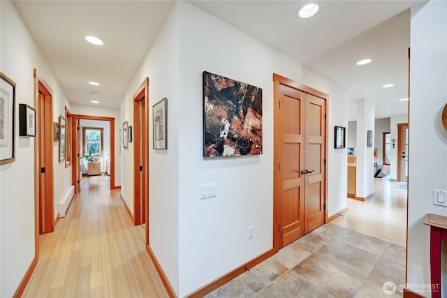 hallway with light wood finished floors, recessed lighting, baseboards, and a baseboard radiator