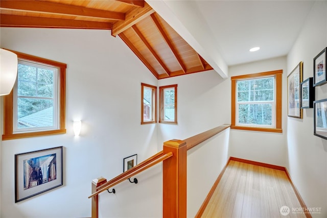 hallway with light wood-type flooring, an upstairs landing, wooden ceiling, baseboards, and vaulted ceiling with beams