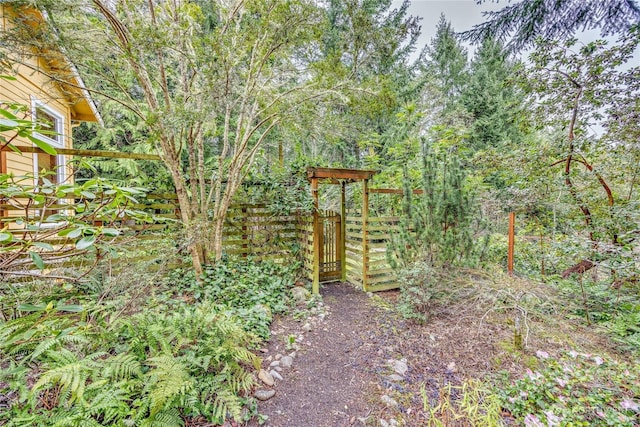 view of yard featuring a view of trees and fence