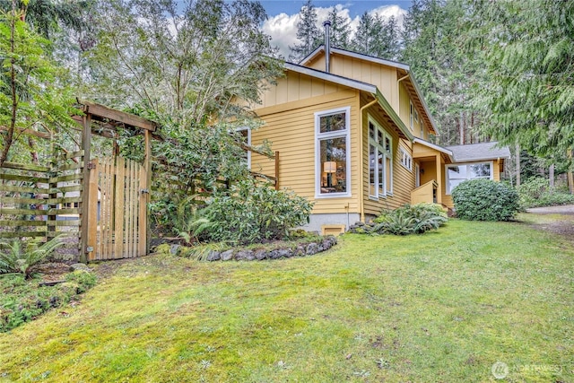 view of front facade with a front lawn, fence, and board and batten siding