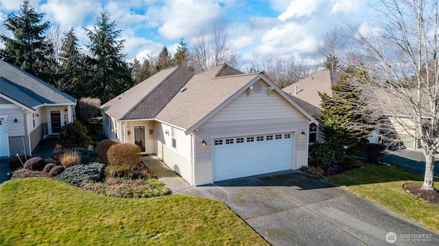 view of front of property with a front lawn, roof with shingles, concrete driveway, and an attached garage