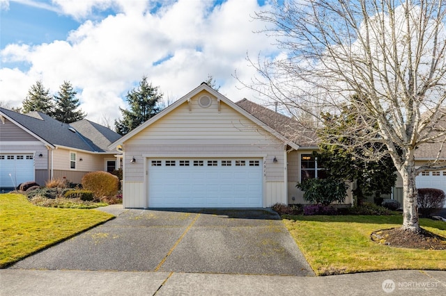 view of front of home featuring aphalt driveway, a garage, and a front lawn