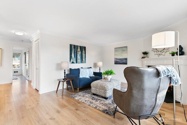 living area with light wood finished floors, crown molding, and baseboards