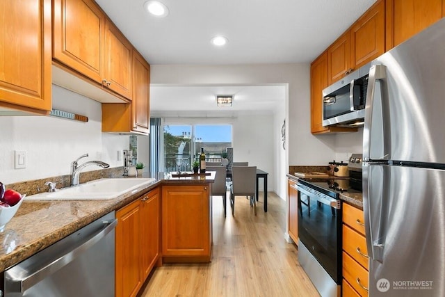 kitchen with brown cabinets, stainless steel appliances, and a sink