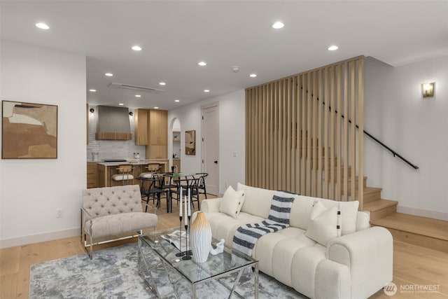 living room featuring recessed lighting, stairway, baseboards, and light wood-style floors