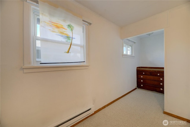 unfurnished bedroom featuring a baseboard heating unit, crown molding, carpet flooring, and baseboards