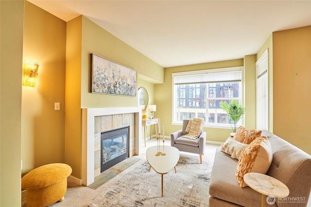 carpeted living room with baseboards and a tile fireplace