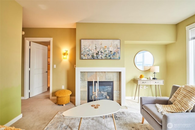 carpeted living room featuring baseboards and a tile fireplace