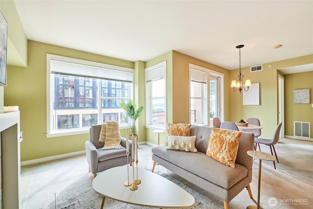 living room featuring light carpet, visible vents, baseboards, and an inviting chandelier