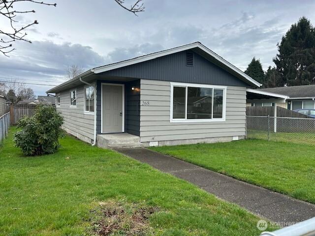 bungalow with a carport, a front yard, and fence