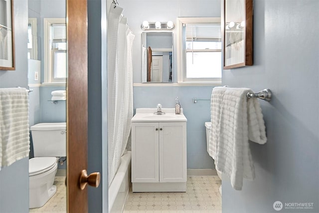 bathroom with a wealth of natural light, toilet, and tile patterned floors