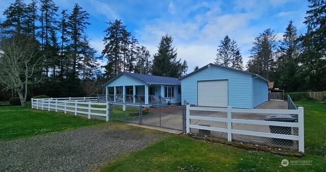 exterior space featuring a garage, an outbuilding, concrete driveway, and fence