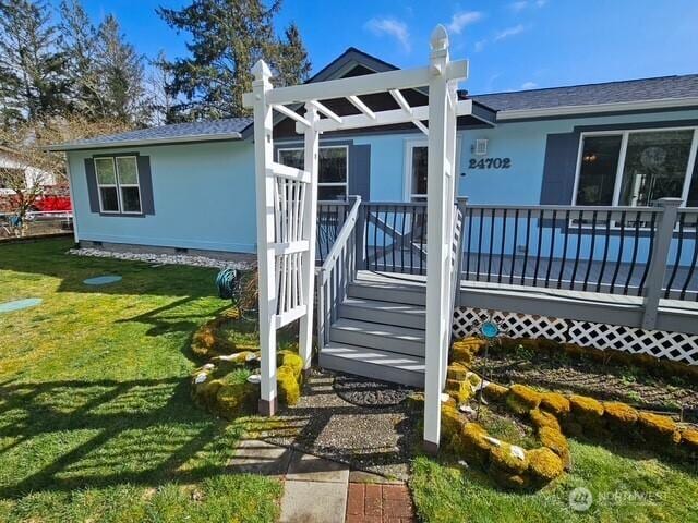 view of exterior entry featuring crawl space and a lawn