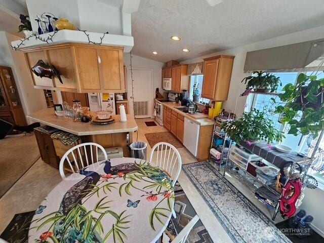 kitchen featuring light countertops, vaulted ceiling, recessed lighting, white appliances, and a sink