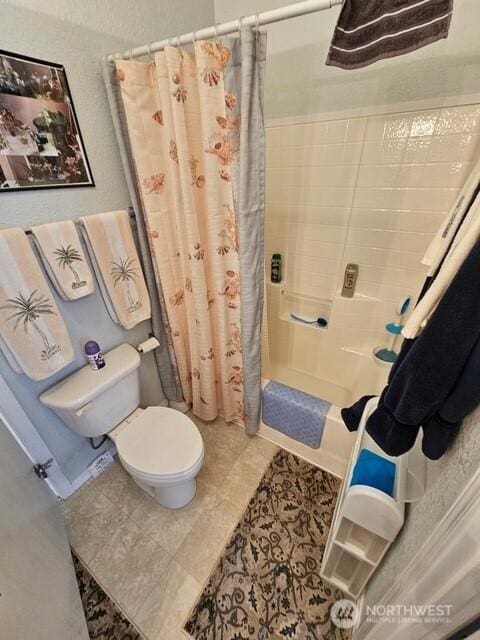 full bathroom featuring shower / tub combo and toilet