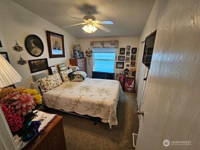 bedroom featuring visible vents, a ceiling fan, carpet, and vaulted ceiling