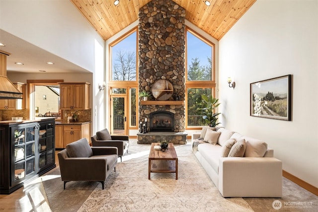 living area featuring a healthy amount of sunlight, a fireplace, and wooden ceiling