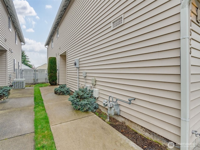 view of home's exterior featuring a patio area, central AC unit, and fence