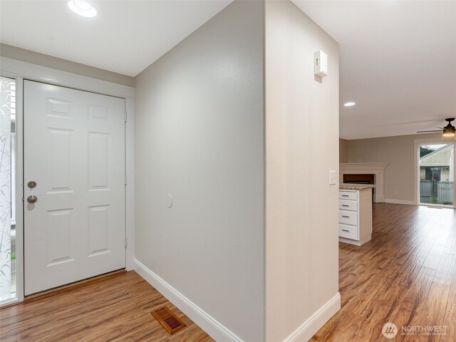 entrance foyer with a ceiling fan, light wood-style flooring, visible vents, and baseboards