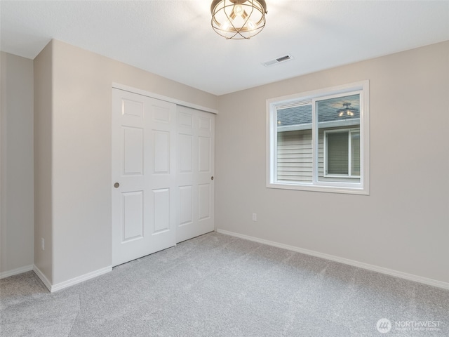 unfurnished bedroom with visible vents, baseboards, and carpet flooring