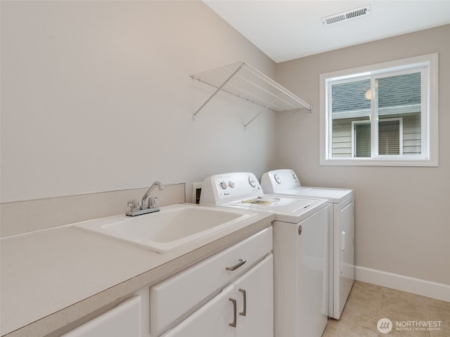 laundry room featuring baseboards, visible vents, light tile patterned flooring, separate washer and dryer, and a sink