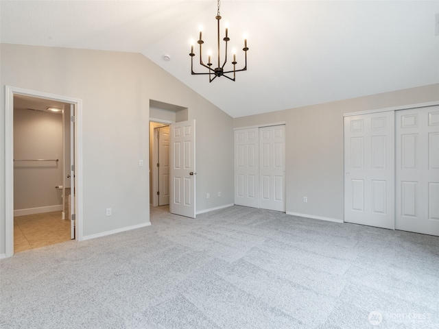 unfurnished bedroom with carpet, baseboards, lofted ceiling, two closets, and a chandelier