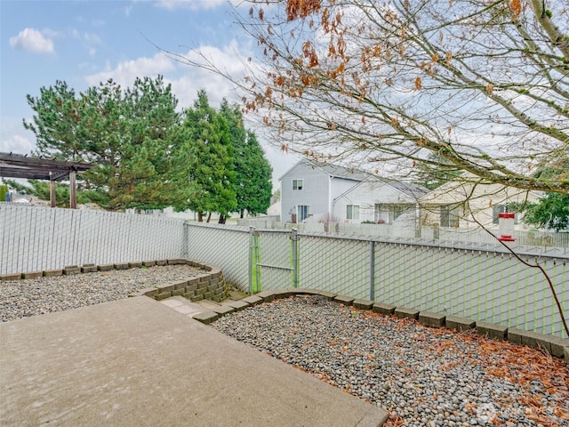 view of yard featuring a gate, a fenced backyard, and a pergola