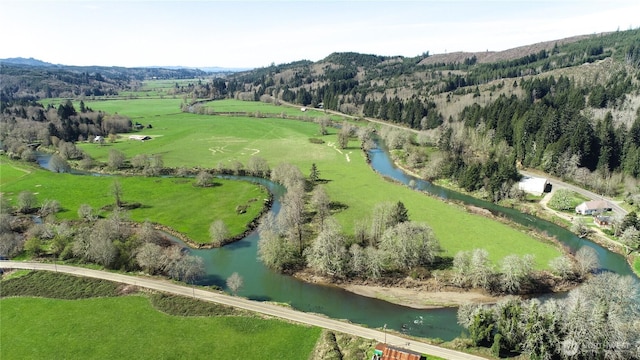 drone / aerial view with a water and mountain view and a rural view