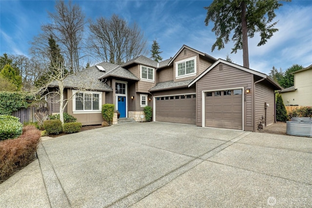 view of front of house featuring fence, driveway, and a shingled roof