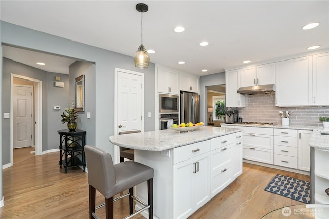 kitchen with white cabinets, light wood-type flooring, under cabinet range hood, and stainless steel appliances