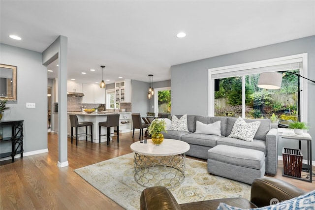 living room featuring recessed lighting, baseboards, and wood finished floors