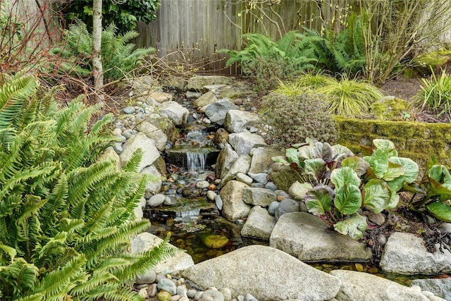 details featuring a garden pond and fence