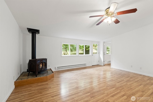 unfurnished living room featuring baseboards, a wood stove, ceiling fan, light wood-type flooring, and baseboard heating