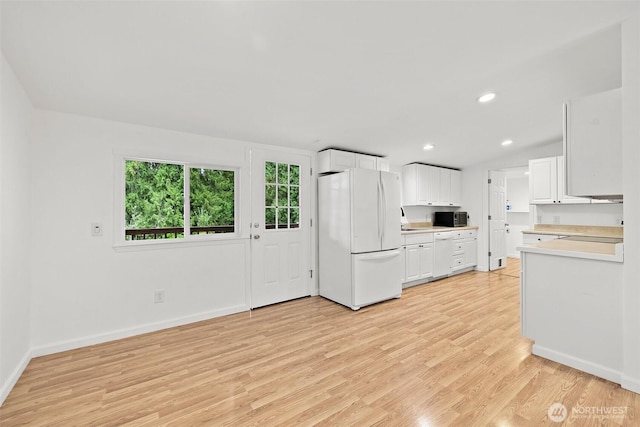 kitchen with white appliances, recessed lighting, light countertops, white cabinetry, and light wood-type flooring