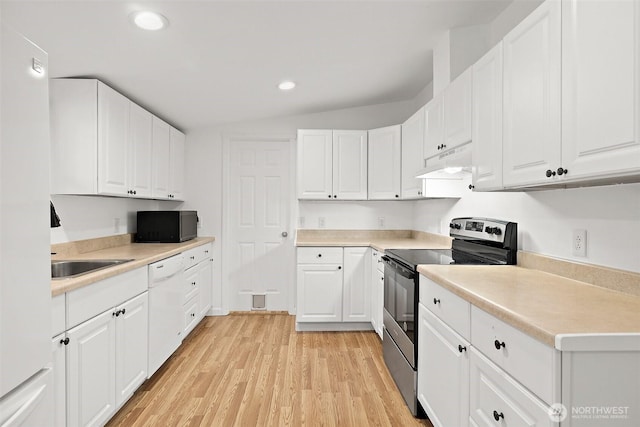 kitchen featuring light wood finished floors, black microwave, under cabinet range hood, stainless steel range with electric cooktop, and white cabinets