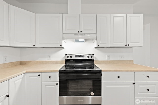 kitchen with under cabinet range hood, stainless steel electric stove, white cabinets, and light countertops