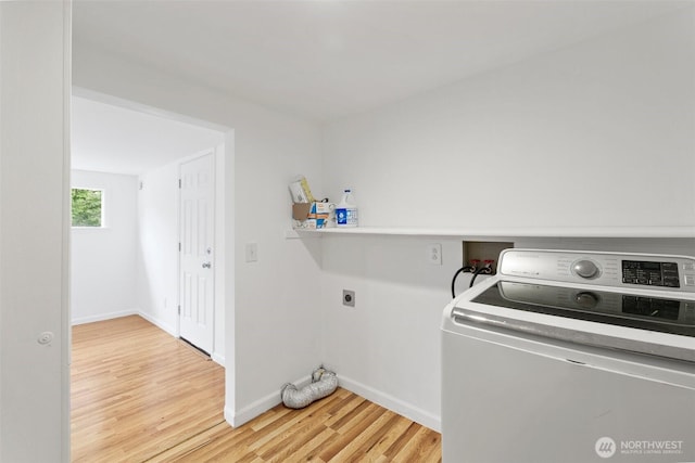 laundry room featuring washer / dryer, baseboards, and light wood-style floors