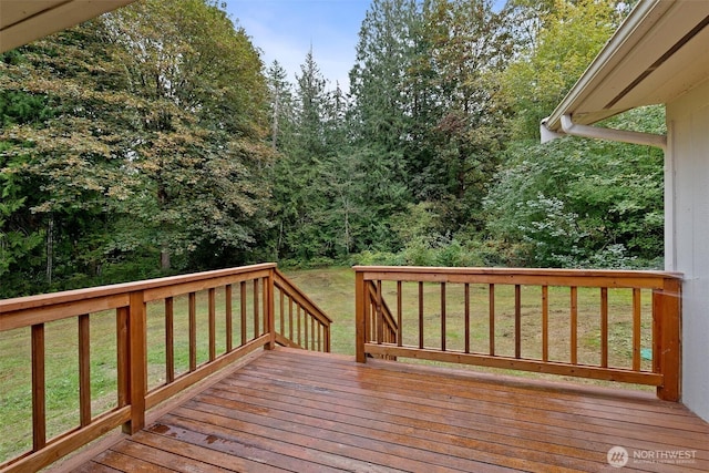 wooden terrace featuring a yard