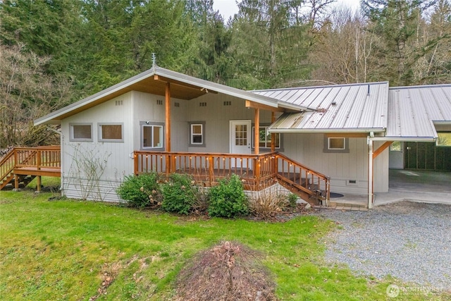 view of front of property featuring stairs, a carport, a front lawn, a deck, and metal roof