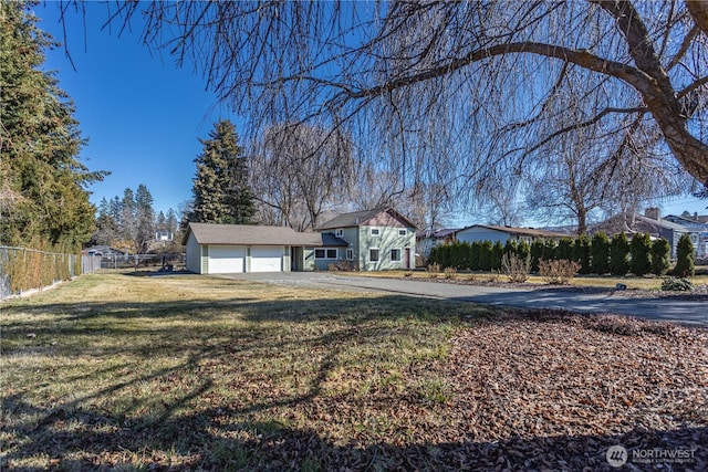 view of front of home featuring a front yard, fence, and driveway