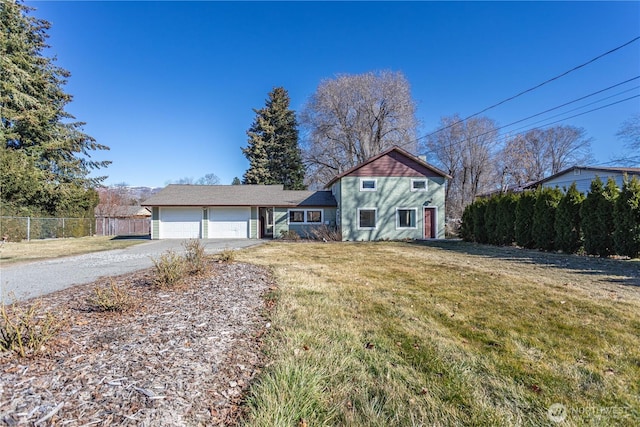 view of front facade with a front yard, concrete driveway, an attached garage, and fence