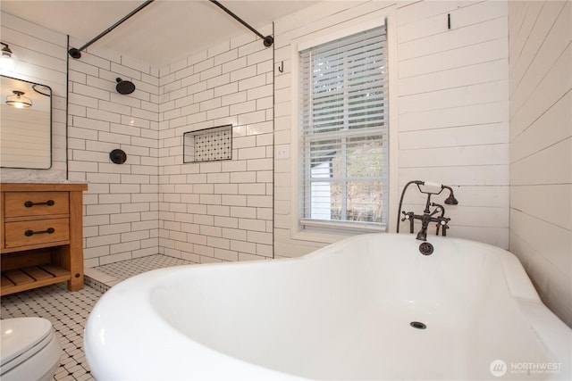 bathroom featuring tiled shower, toilet, and a freestanding bath