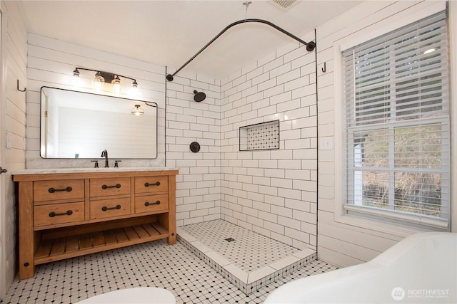 full bathroom with tile patterned floors, tiled shower, toilet, and vanity