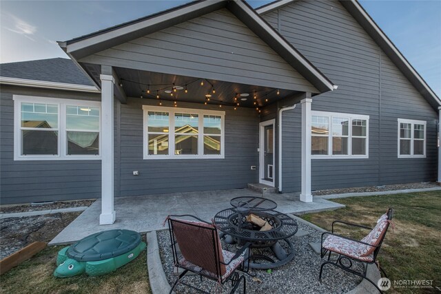 rear view of property with a patio and a fire pit