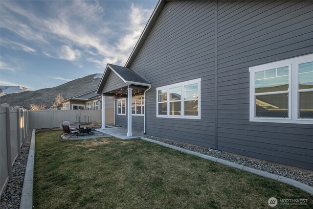 back of house with a patio area, a lawn, a mountain view, and a fenced backyard