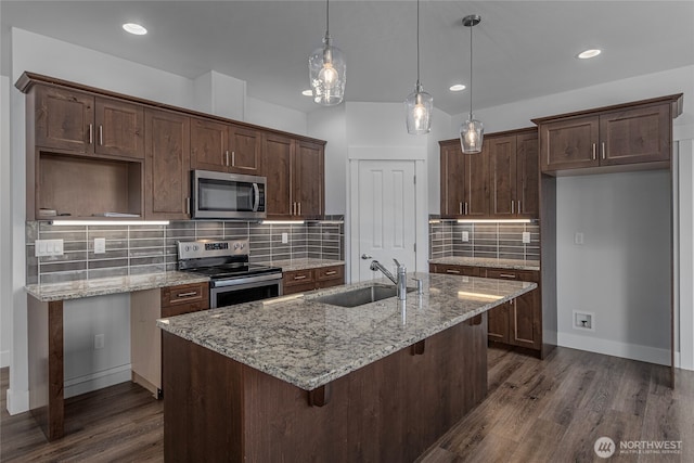 kitchen featuring a sink, stainless steel appliances, an island with sink, and dark wood finished floors