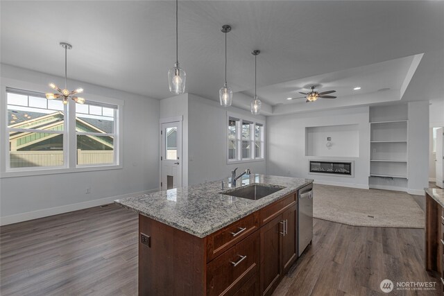 kitchen featuring dark wood-style flooring, a raised ceiling, baseboards, and a sink