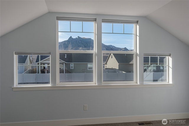 bonus room with plenty of natural light, a mountain view, and vaulted ceiling