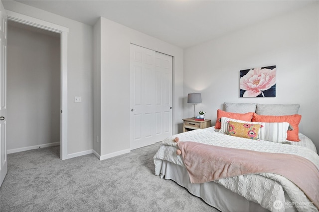 bedroom with a closet, baseboards, and carpet